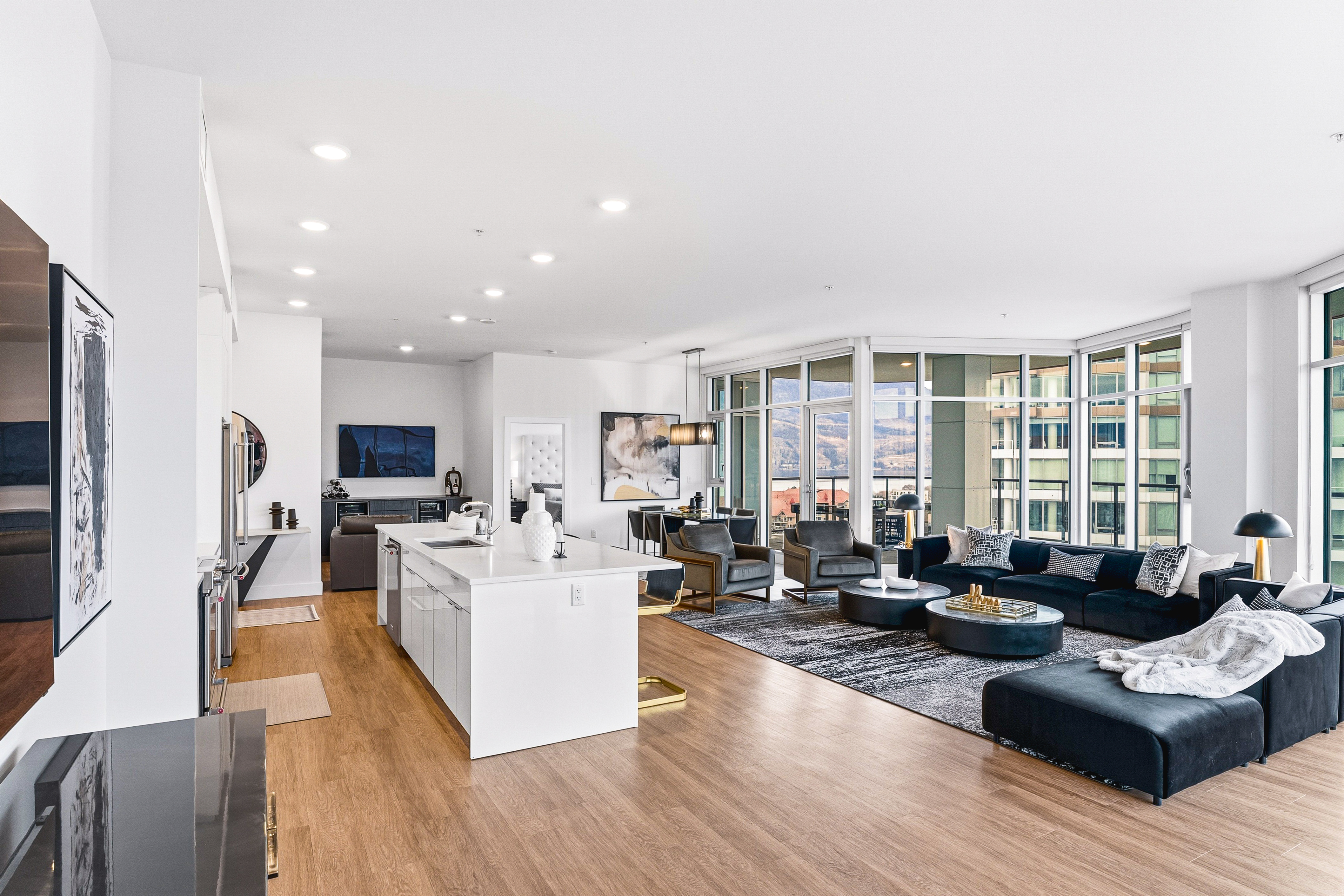 Wide open-plan living room with curved floor-to-ceiling windows and lake views