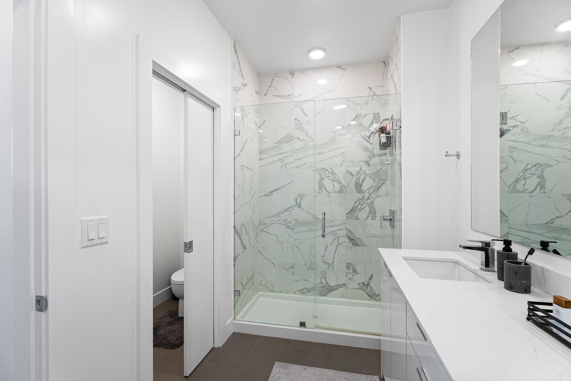 Second bedroom ensuite with marble walls and a double-sink vanity