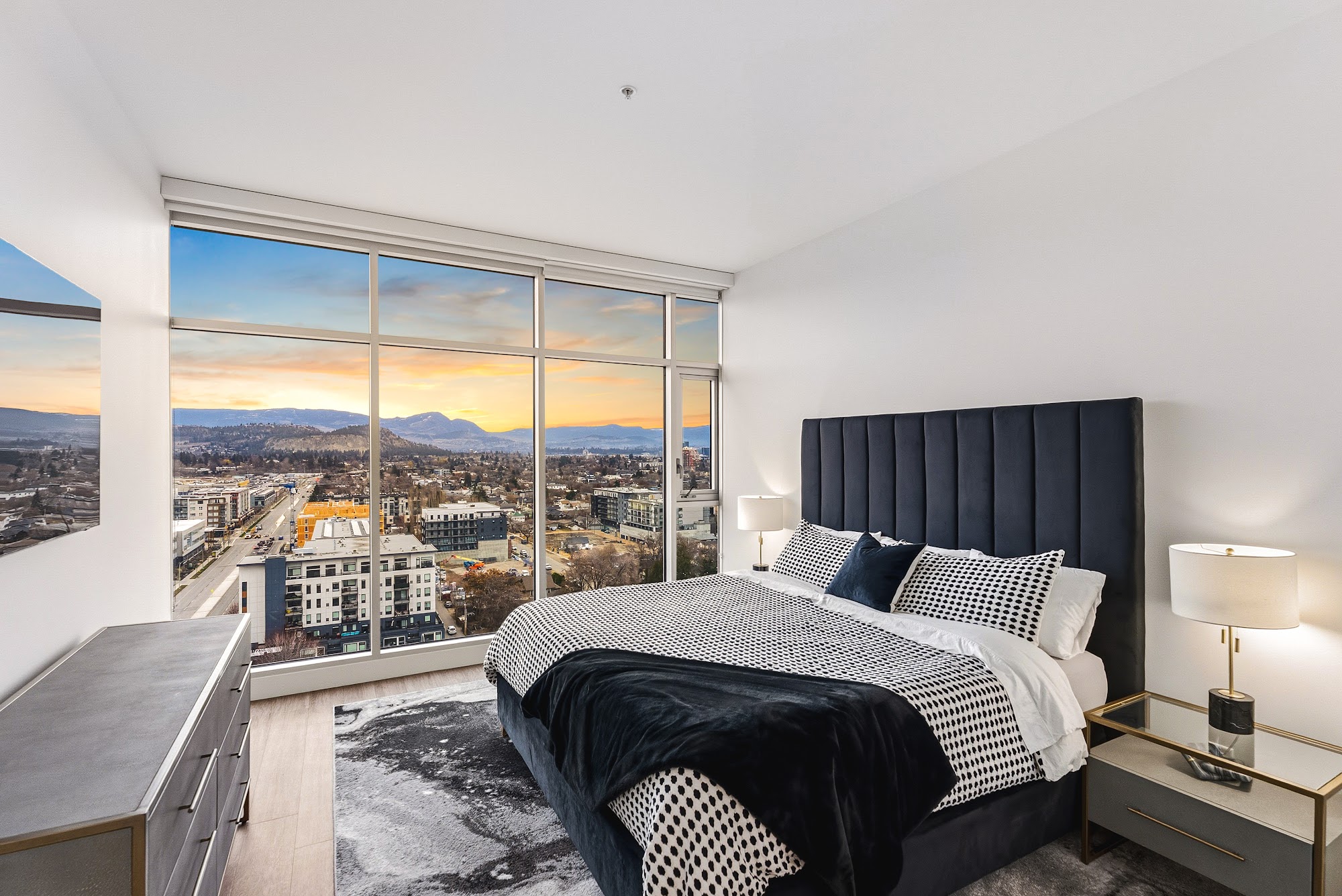 Third bedroom with king bed, navy bedding, and the downtown skyline from the window line