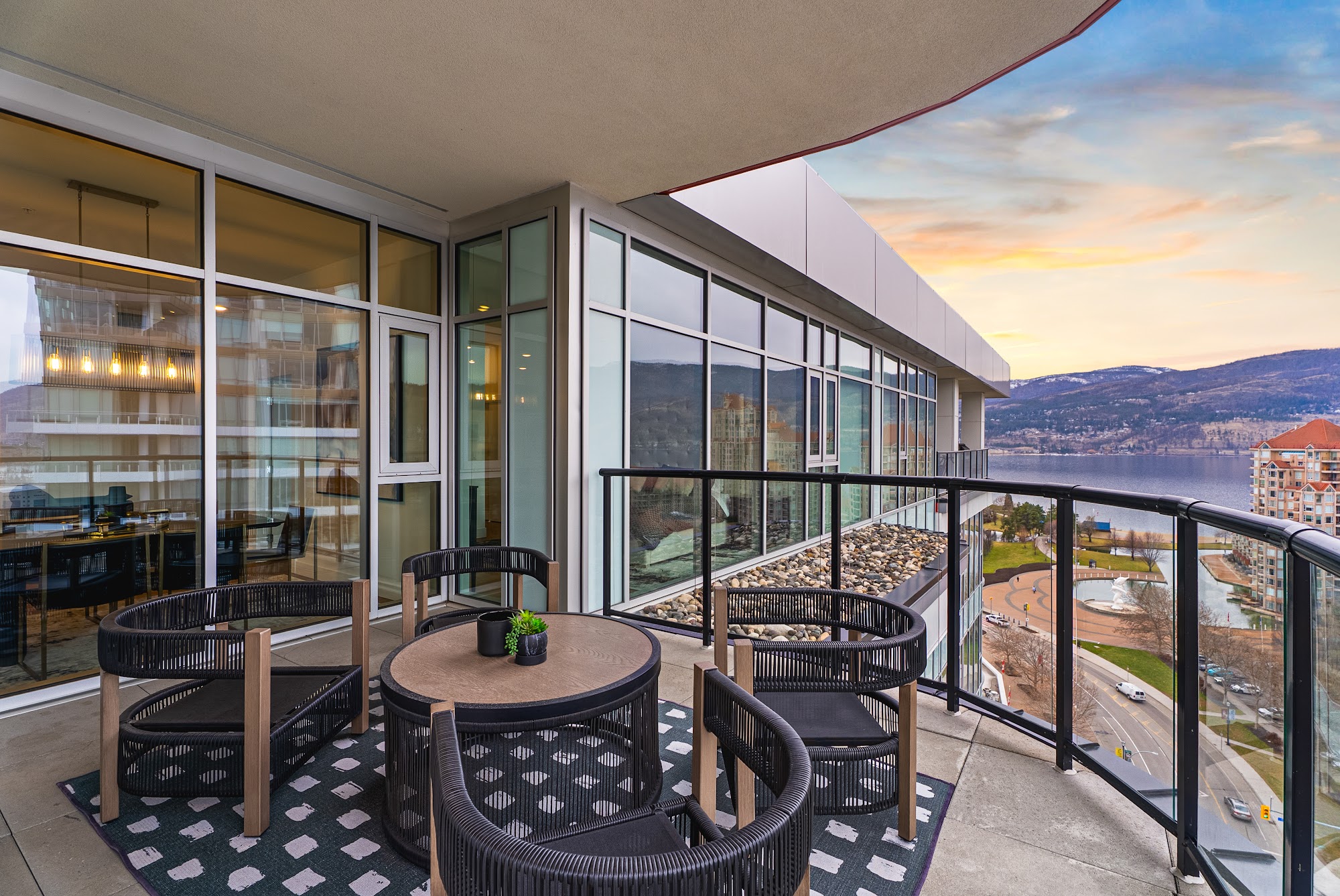 Wrap-around deck with the outdoor dining set and the lake on the other side of the corner
