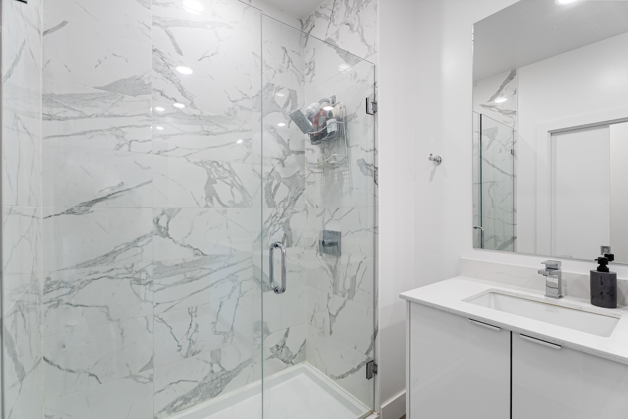 Glass-enclosed marble shower in the third bathroom