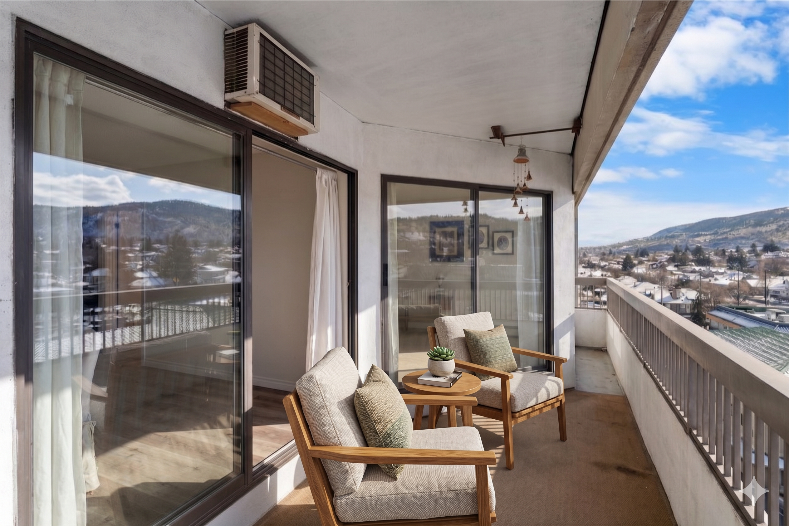 Virtually staged balcony with patio chairs and side table looking out at the mountains