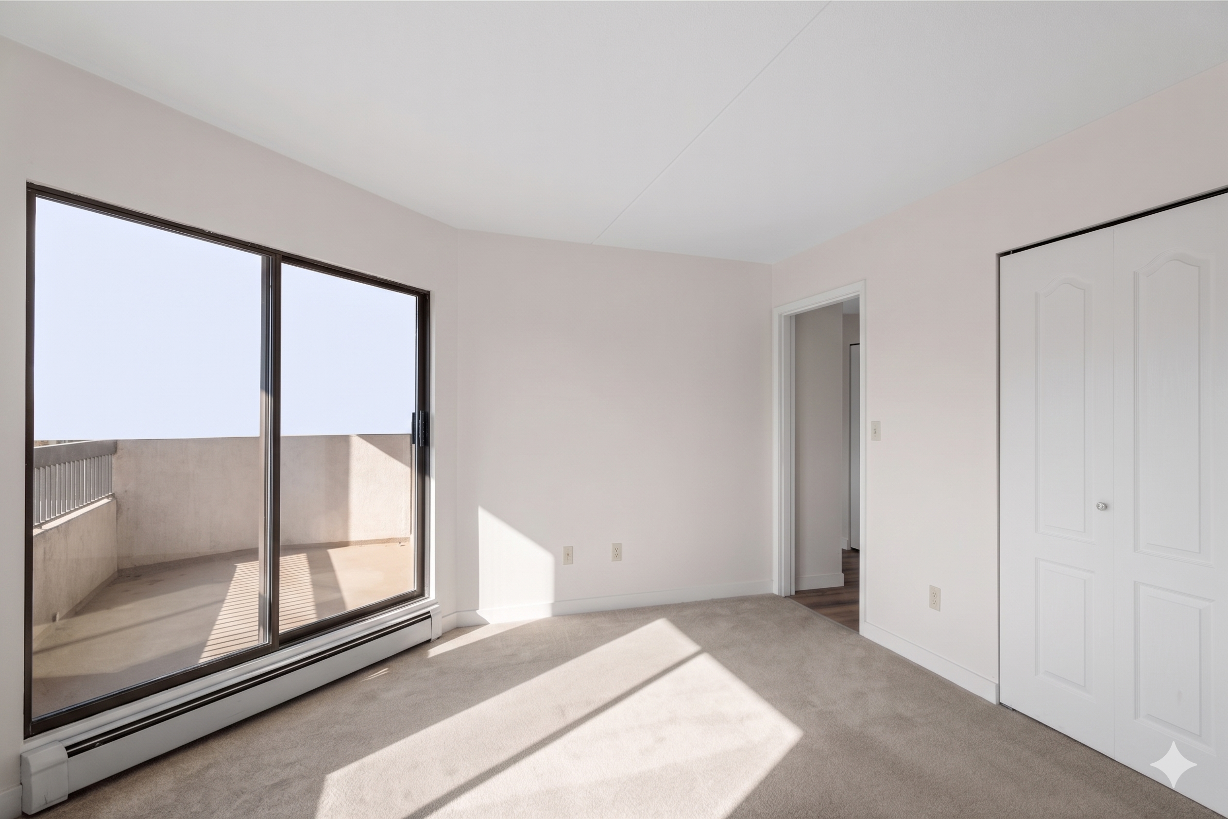 Empty bedroom with closet and sliding doors to the balcony