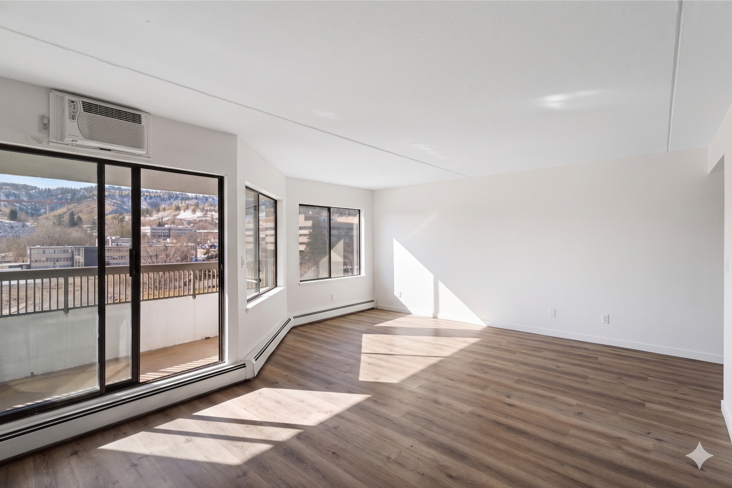Wide empty living room with windows and balcony access